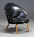 Dansk møbelproducent. Skalformet lænestol, sort læder