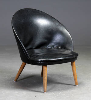 Dansk møbelproducent. Skalformet lænestol, sort læder