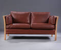 Mogens Hansen. Fritstående to-pers. sofa med tremmestel af bøgetræ betrukket med brunt skind,