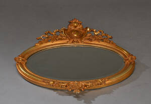 Ovalt spejl af forgyldt træ og gesso, 181900-tallet.