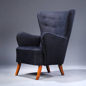 Dansk møbelproducent. Lænestol nybetrukket med delvis knapsyet blå-sort nistret stof