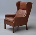 Dansk møbelproducent. Øreklapstol af brunt læder 