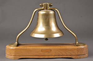 Skibsklokke af messing monteret på fod af træ
