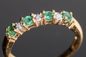 Alliancering i guld 18k med smaragder och diamanter