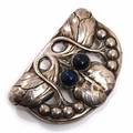 Evald Nielsen Skønvirkebroche af sølv rigt prydet med stiliseret bladornamentik og cabochonslebet lapis lazuli. L. ca. 7 cm. Ca. 1910-20.
