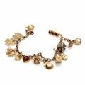 Armbånd af 14 kt. guld prydet med talrige charms med forskellige motiver. L. ca. 19,5 cm. Vægt ca. 21,5 gram.