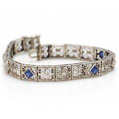 Et diamantarmbånd af 14 kt. hvidguld prydet med talrige diamanter med ældre slibning samt blå sten. L. ca. 17,5 cm. Ca. 1930-40.