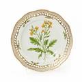 Flora Danica tallerken af porcelæn med gennembrudt bort, dekoreret i farver og guld med blomster. 3553. Royal Copenhagen. Diam. 25 cm.