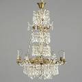 Lysekrone af messing rigt behængt med prismer. Louis XVI form. Ca. 1900. H. 78. Diam 57.