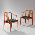 Hans J. Wegner Kinastolen. Et par armstole af mahogni. Løse dybthæftede sædehynder betrukket med sort skind. 2