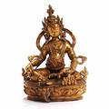 Nordindisk buddha figur af forgyldt bronze, dekoreret med farvede glassten, siddende på base. 19.-20. årh. H. 33.