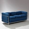 Le Corbusier LC 2. Fritstående tre-personers sofa med stel af stål. Sæde, ryg, løse hynder og armlæn betrukket med blåt stof.