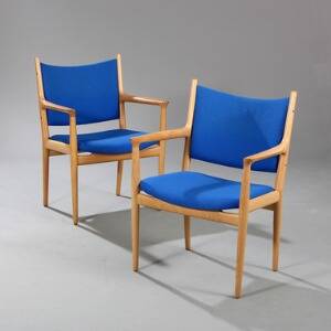 Hans J. Wegner JH 513. Et par armstole af eg, betrukket i sæde og ryg med lys blå uld. Udført hos Johannes Hansen. 2