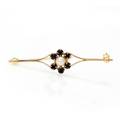Perle- og safirbroche af 8 kt. guld prydet med kulturperle omkranset af facetslebne safirer. L. ca. 5 cm.