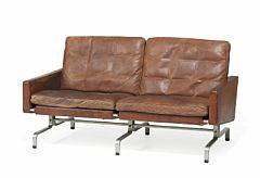 Poul Kjærholm PK-312. Fritstående to-personers sofa med stel af matforkromet stål. Sider, ryg samt løse hynder i sæde og ryg betrukket med brunt skind.