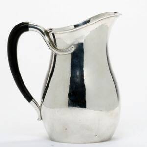 Evald Nielsen Vandkande af hammerslået sterlingsølv. Smedet med kugleornamentik og forsynet med hank af ibenholt. H. 17,5.