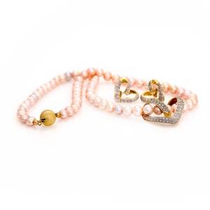 Diamantsmykkesæt af 14 kt. guld og hvidguld bestående af vedhæng og ørestikker hver prydet med talrige enkeltslebne diamanter samt perlekæde af forgyldt sølv.