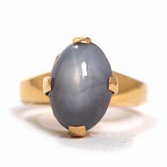 Stjernesafirring af guld prydet med cabochonslebet stjernesafir. Vægt ca. 8 gr. Str. 53. Ca. 1960.