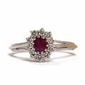 Rubin- og diamantring af 18 kt. hvidguld prydet med facetslebet rubin omkranset af talrige brillantslebne diamanter. Str. 56.