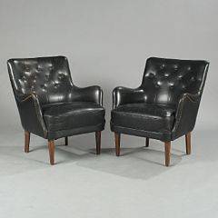 Dansk møbeldesign Et par lænestole betrukket med sort skind beslået med messingsøm, ryg med knapper, ben af bejdset bøg. 1950erne. 2