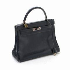 Hermès Kelly 28 taske af marineblåt boxlæder med gyldent beslag, hængelås, nøgler, nøglesnor og tre indvendige lommer.