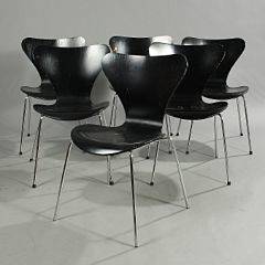 Arne Jacobsen Syveren. Sæt på seks stabelstole opsat på ben af forkromet metal. Skalformet sæde og ryg af sortlakeret formbøjet træ. 6