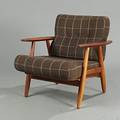 Hans J. Wegner Cigaren. Lænestol med stel af eg og armlæn af teak, løse uoriginale hynder med brunt betræk. Udført hos Getama.