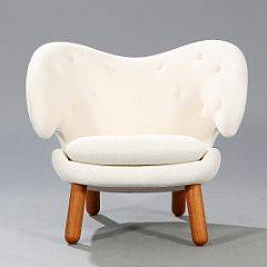 Finn Juhl Pelikanen. Lænestol med ben af teak. Sæde, sider og ryg betrukket med dybthæftet lys uld. Udført hos OneCollection.