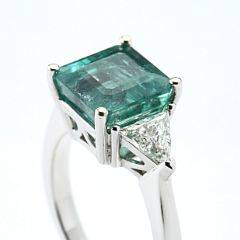 Smaragd- og diamantring af 18 kt. hvidguld prydet med smaragdslebet smaragd på ca. 3.35 ct. flankeret af to trillantslebne diamanter. Str. 52. Ca. 2009.