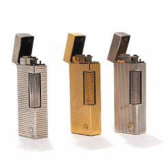 Tre Dunhill lightere, den ene forgyldt. H. 6,4. B. 2,4 cm. 3
