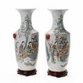Et par kinesiske vaser af porcelæn, balusterformede, dekorerede med  kvinder i interior med børn. 20. årh. H. 57 cm.  Stand af træ medfølger. 2
