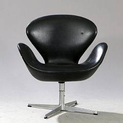 Arne Jacobsen Svanen. Lænestol med helstøbt profileret fod af aluminium. Sider og sæde betrukket med sort vinyl. Udført hos Fritz Hansen.