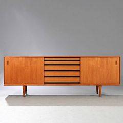 Dansk møbeldesign Skænk af teak på tilspidsende ben. Front med fire skuffer og to skydelåger bag hvilke hylder.