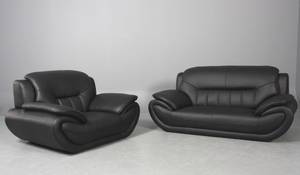 Moderne lænestol samt to-pers sofa betrukket med sort imiteret læder. 2