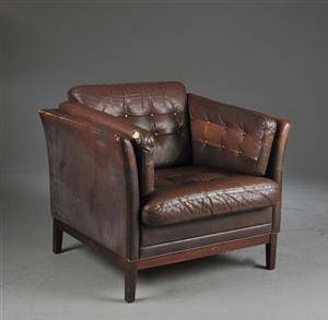 Lænestol med betræk og løse hynder af brunt skind, på firkantede ben,.