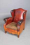 Lænestol betrukket med cognacfarvet læder.