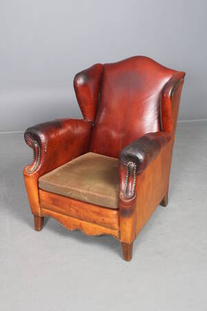 Lænestol betrukket med cognacfarvet læder.