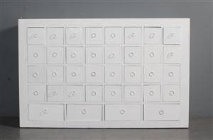 Hvidlakeret kommode med talrige skuffer.