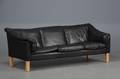 Sofa betrukket med sort læder, ben af bøg