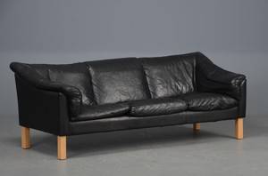 Sofa betrukket med sort læder, ben af bøg