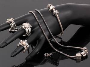 Samling ringe, armlænke og halskæde med charms, bl.a. Pandora og Spinning 23