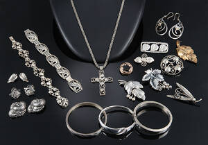 En samling smykker af sølv og sterlingsølv dekoreret med stiliserede blad- og blomstermotiver, overvejende 1900-tallets midte 22