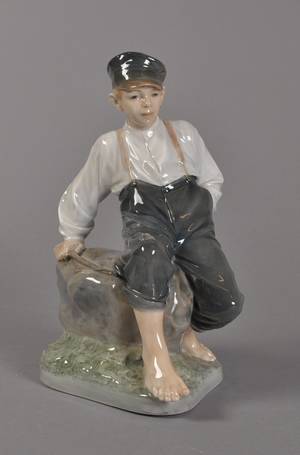 Kgl. P. - dreng siddende på sten i porcelæn - nr. 1659 1. sort.