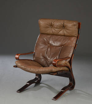 Lænestol med stel af mørk poleret bøgetræ, hynde og nakkepude monteret med brunt skind. 