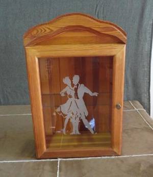 Väggskåp med etsad dekoration på glasdörren