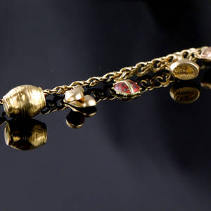 Guld armbånd med charms.
