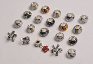 20 Charlotte Borgen charms i sterling sølv, nogle med glas i sorte nuancer