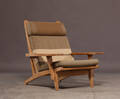 Hans J. Wegner. Højrygget lænestol med stel af massiv egetræ