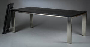 Spisebord med stel af stål og plade af sort træ.