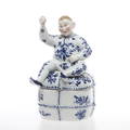 LOCKSKÅL krönt av figurin, porslin, 1900-talets första hälft.